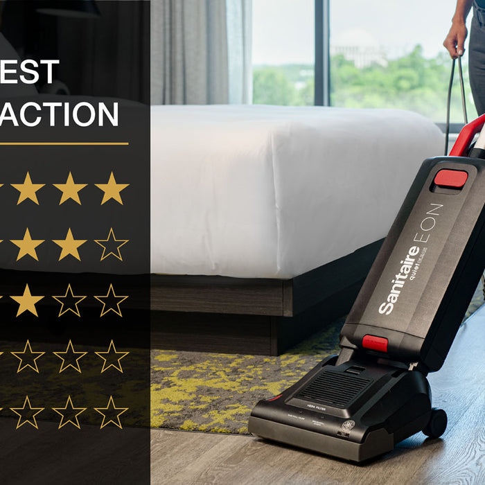 A hotel floor with both carpet and hard floor being cleaned by a housekeeper with a Sanitaire EON multi surface vacuum